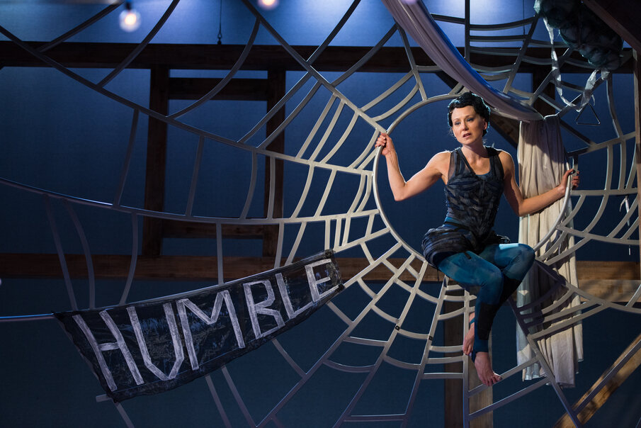 woman in black in a spiderweb that says humble 
