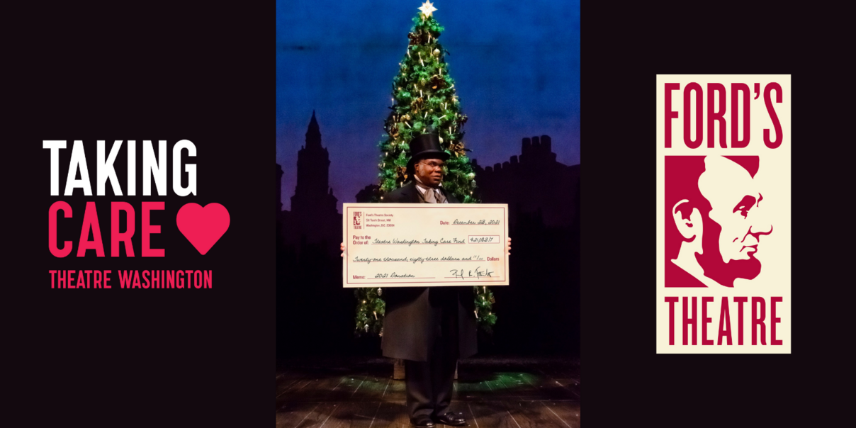actor dressed as Scrooge holds a large check