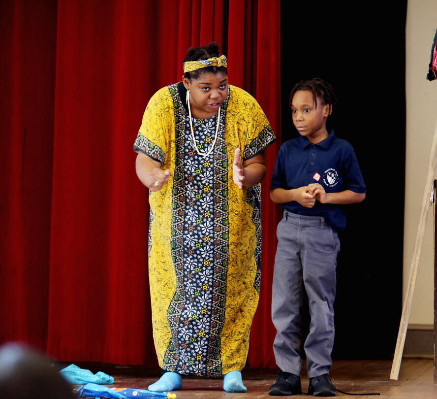 Student on stage participates with cast members of African Folktales at Democracy Prep-Congress Heights TCF Spring 2017 Photo by Sharon C. Farmer 