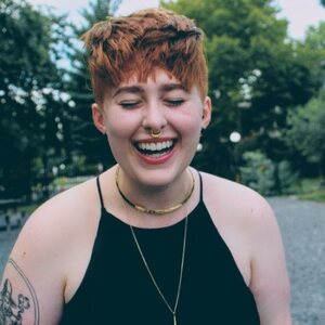 redheaded person with pixie cut laughing