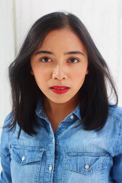 filipino woman with straight shoulder length black hair in a denim button up shirt
