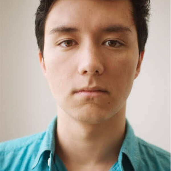 A young chinese-american man with black hair, brown eyes, light skin, in a teal shirt. 