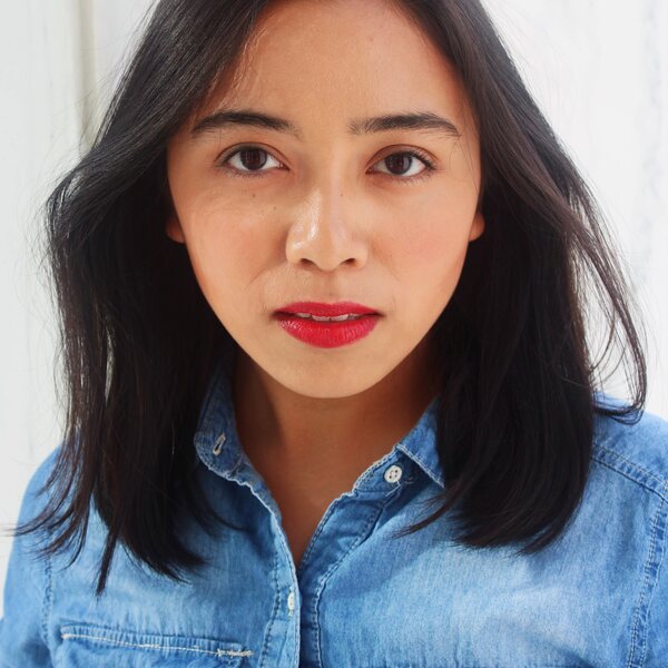 filipino woman with straight shoulder length black hair in a denim button up shirt